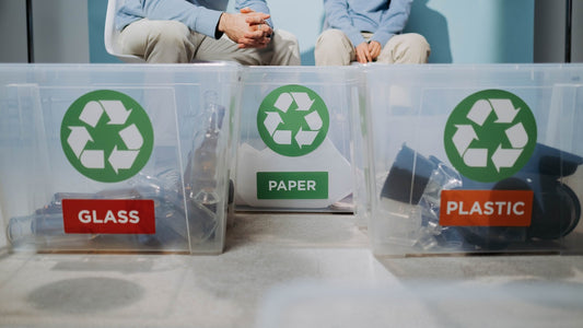Recycling bins labeled glass, paper and plastic