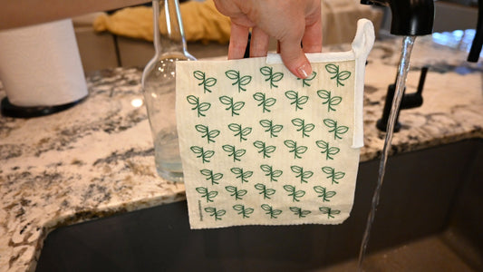 Rinsing a dishcloth under the kitchen tap to remove odors