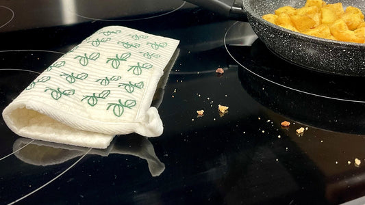Swedish dishcloth on a stovetop beside a pan of eggs