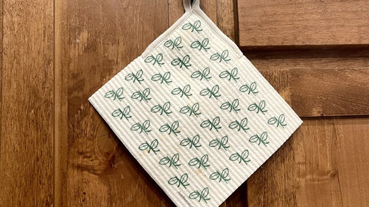 Swedish dishcloth hung by its loop on a kitchen cabinet knob