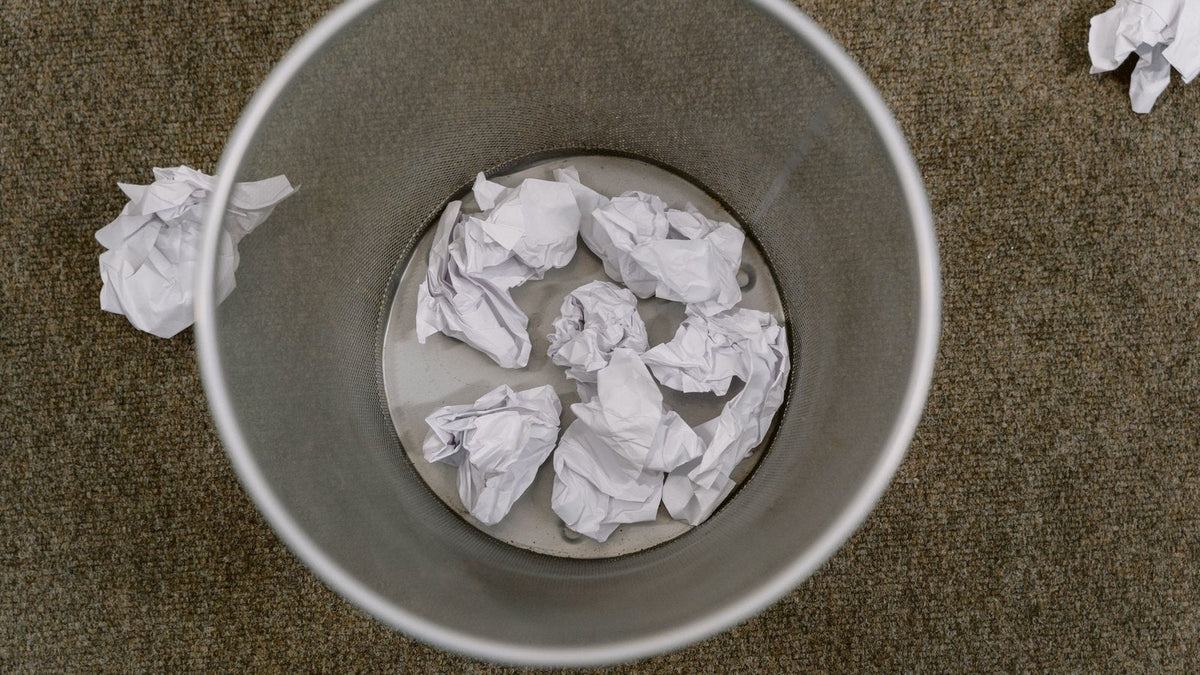 Overhead view of a trash can full of crumpled paper